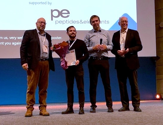 Guido Rattay on stage with his Best Poster Award